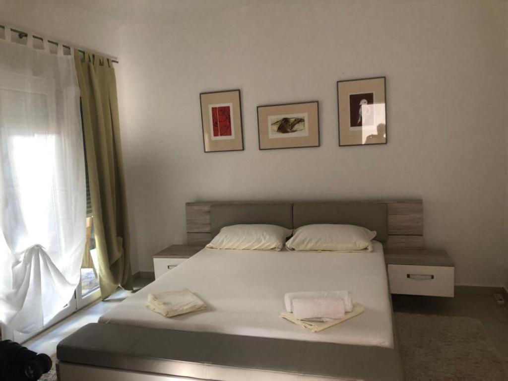 a bedroom with a white bed and a window at Macko, Apartmani in Tivat