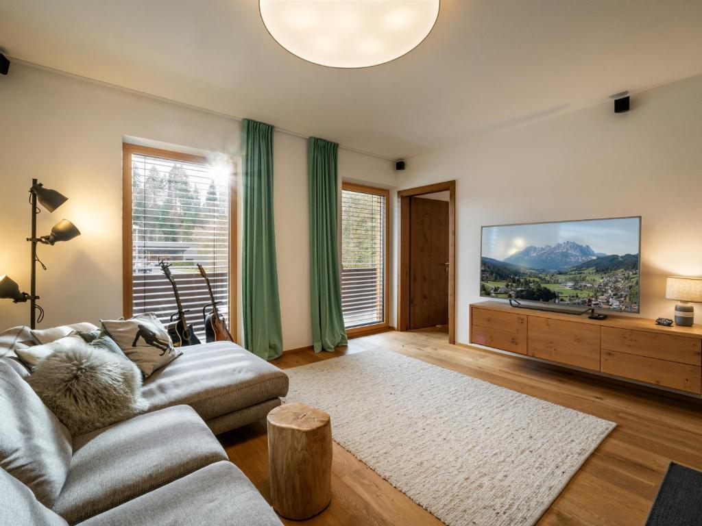a living room with a couch and a flat screen tv at Ferienwohnung Hammerwirt in Fieberbrunn