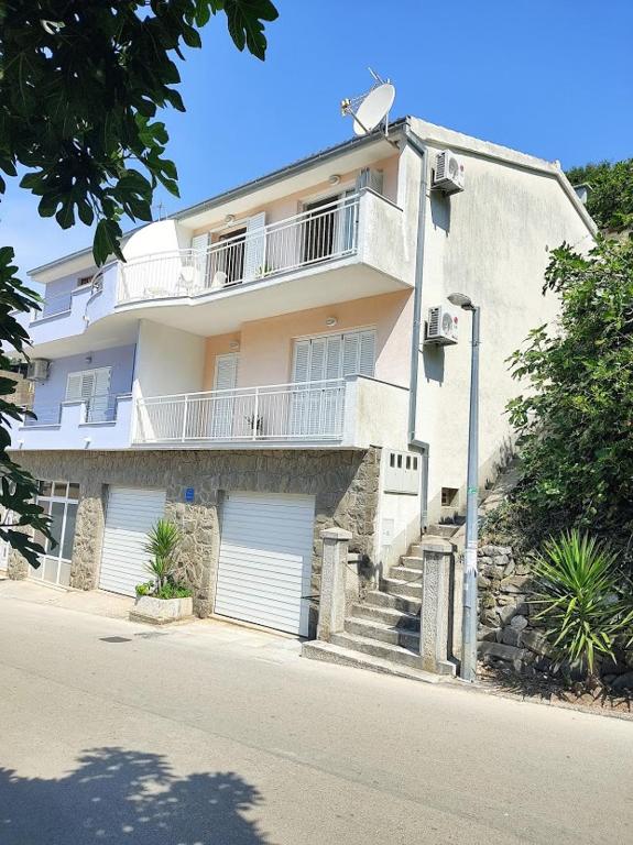 a large white building with stairs and a balcony at Keran 4 in Podgora