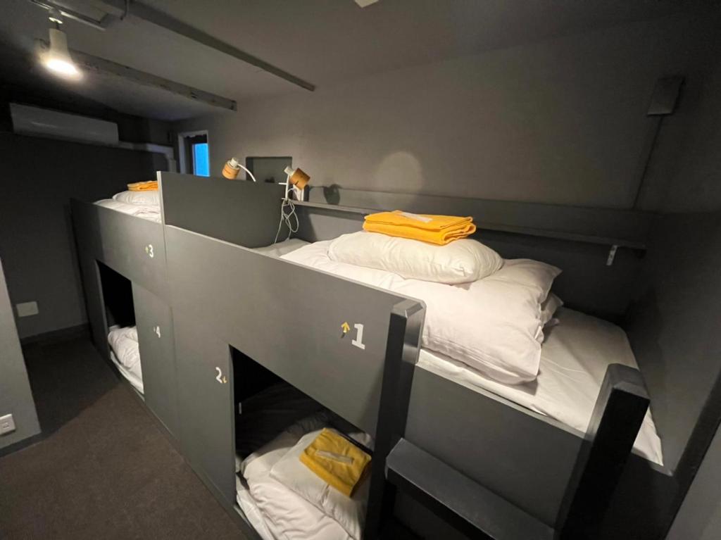 two bunk beds in a small room with towels at Rhodes Otsuka Hotel in Tokyo