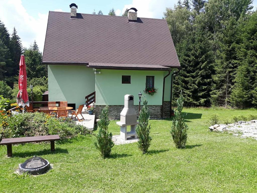 uma casa verde com uma mesa de piquenique e um banco em Chata Lipno em Lipno nad Vltavou