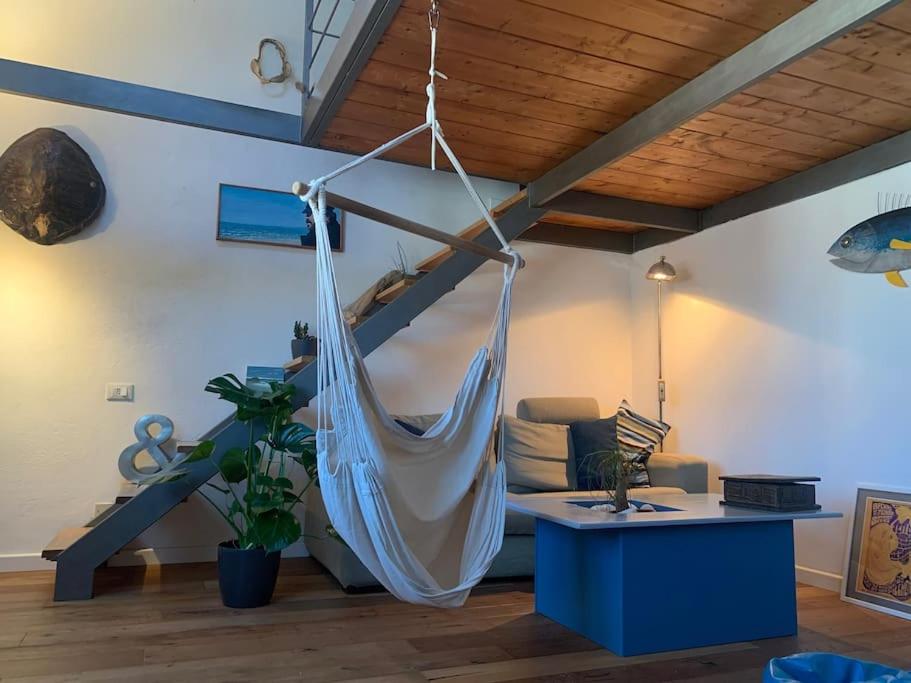 uma sala de estar com uma rede de descanso pendurada no tecto em Loft sul mare em Marina di Pisa