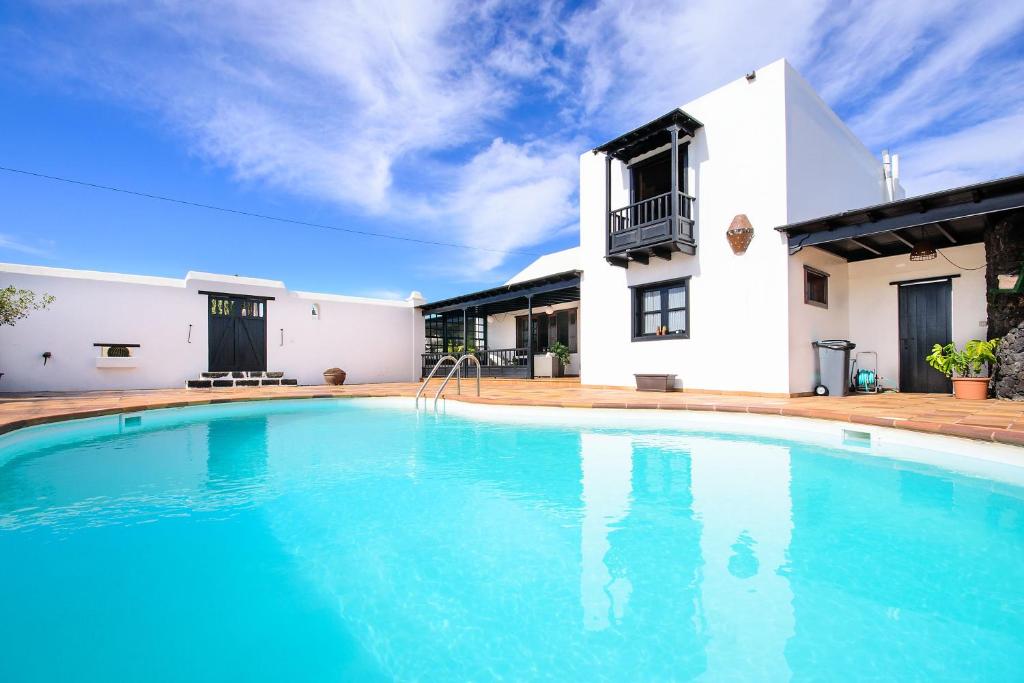 a swimming pool in front of a house at El Islote in San Bartolomé