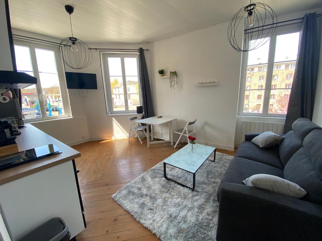 a living room with a couch and a table at Grey Cosy in Louviers