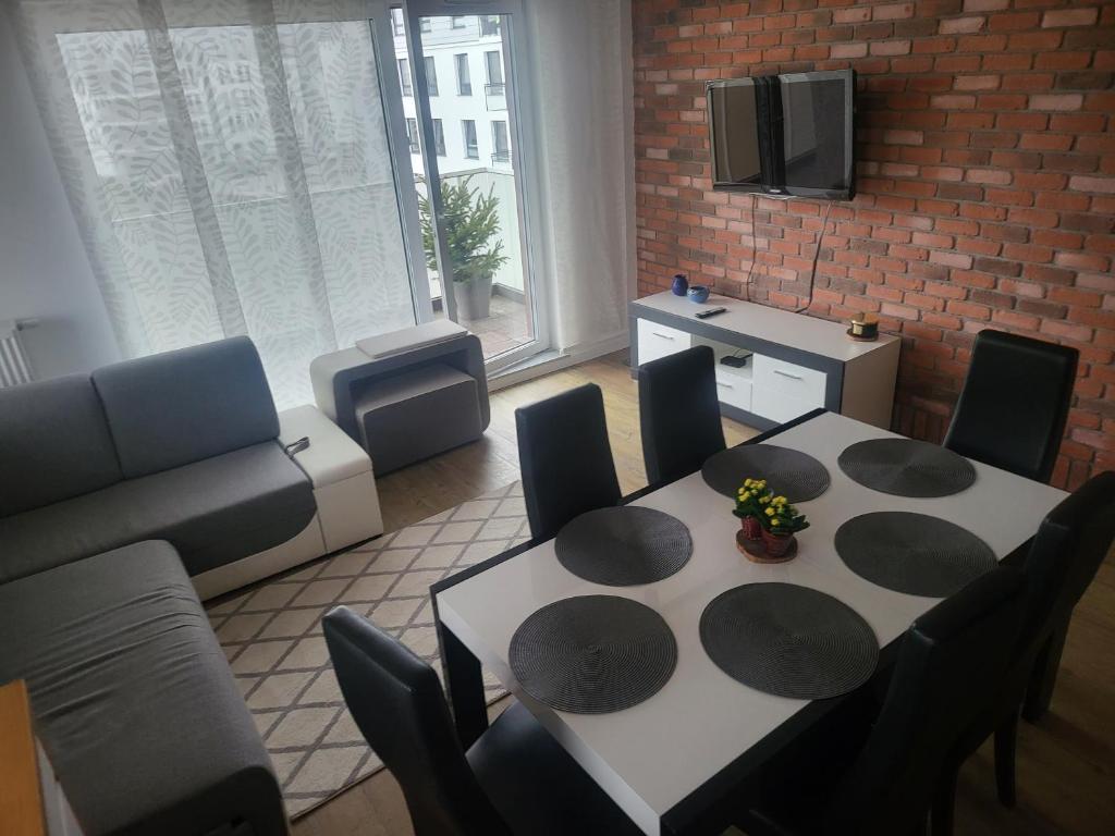 Apartament MAJA (przy Aquaparku w Redzie) في روميا: غرفة معيشة مع طاولة وكراسي وأريكة