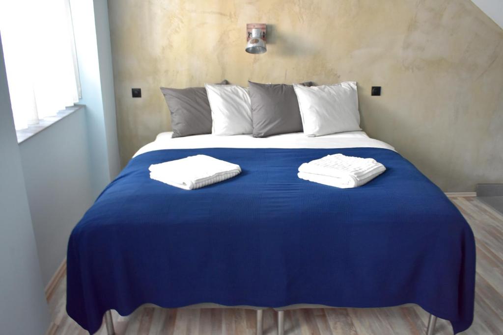 Una gran cama azul con dos toallas blancas. en Residence Řipská 26 en Praga