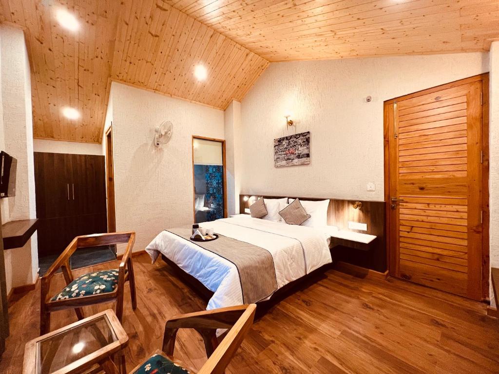 Un dormitorio con una cama grande y un techo de madera. en Yaato Retreat, en Manali