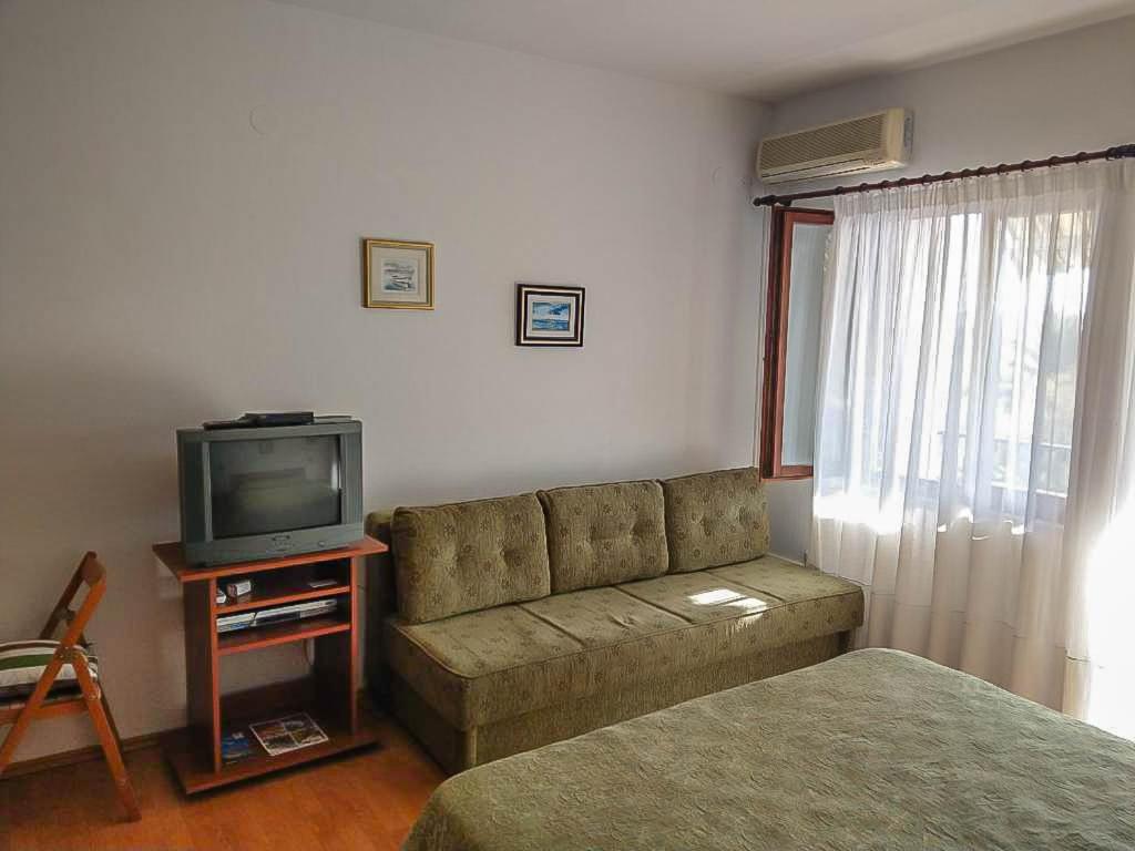 a living room with a couch and a tv at Apartman Melis in Podgora