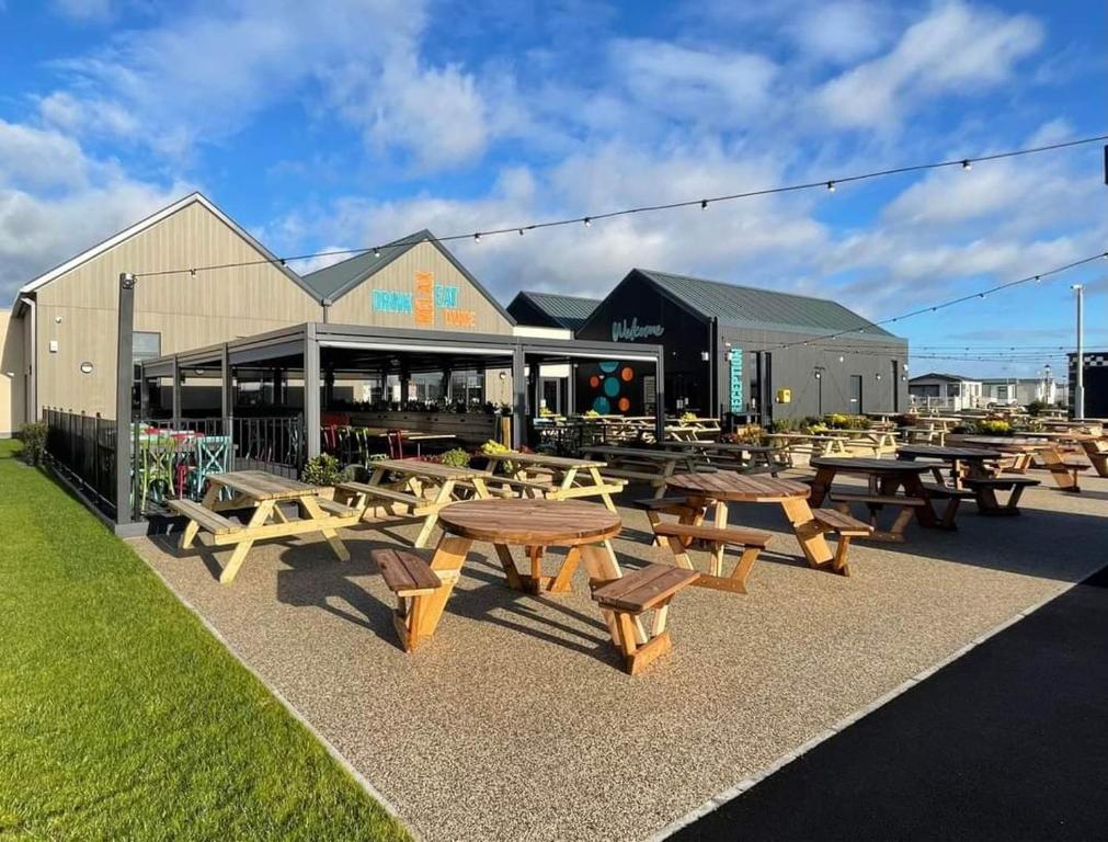 a group of picnic tables in front of a building at Avonmore Martello Beach in Clacton-on-Sea