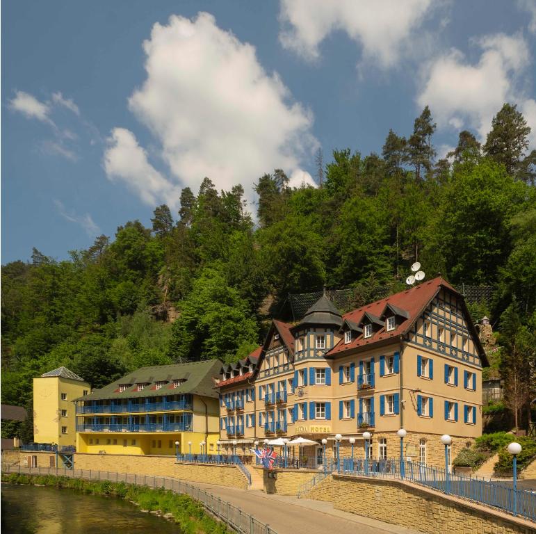 ein großes Gebäude neben einem Wasserkörper in der Unterkunft Hotel Praha in Hřensko