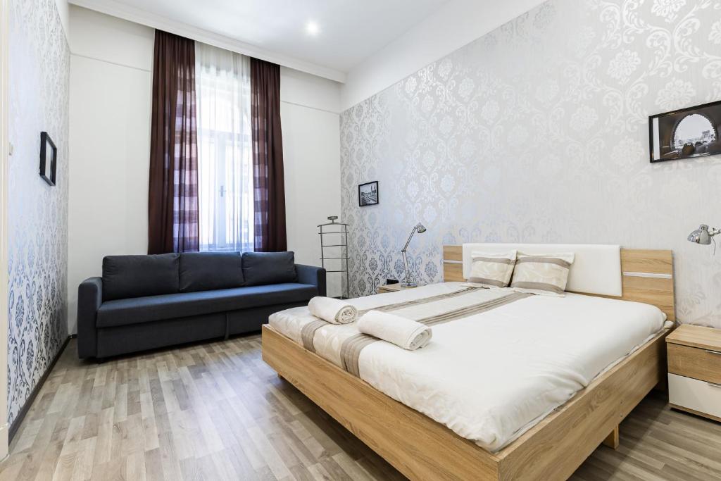 ブダペストにあるReal Apartments Semmelweisのベッドルーム(大型ベッド1台、ソファ付)