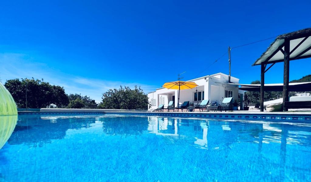 a large swimming pool in front of a white house at THE LOVELY VILLA IBIZA in Ibiza Town