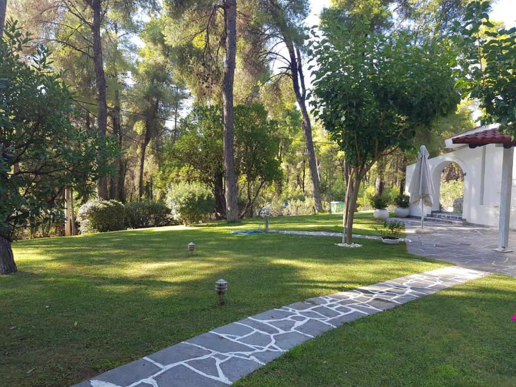 a garden with a stone path in the grass at Sani Villa Christy in Sani Beach