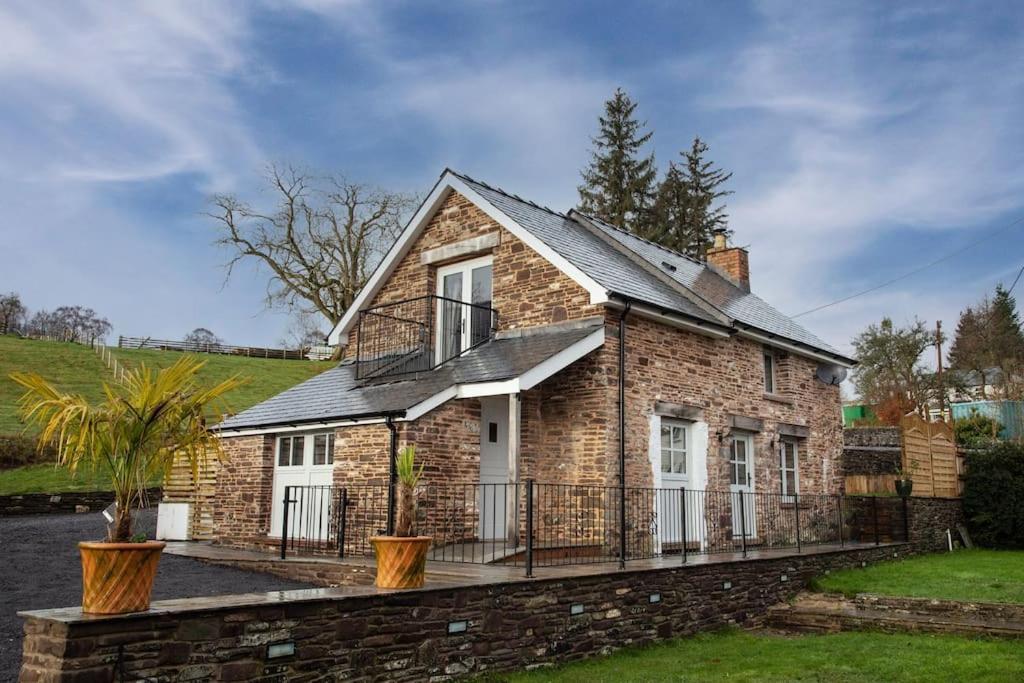 una casa in mattoni con balcone e recinzione di Ty Carreg cottage, Bwlch, Brecon a Brecon