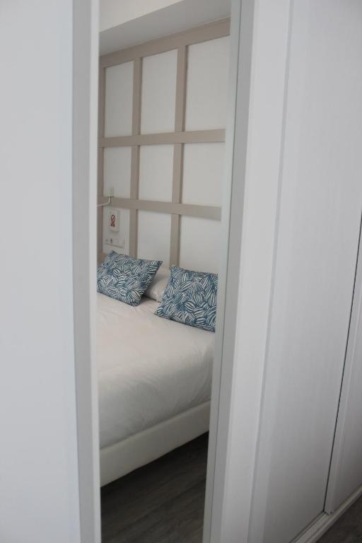 sypialnia z łóżkiem z niebieskimi poduszkami w obiekcie Hotel Boutique Teatro Romano w Maladze
