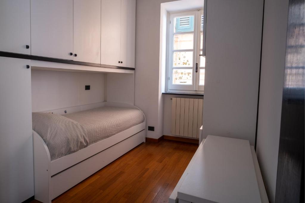 a small bedroom with a bed and a window at Embarcadero with New Powerful WiFi in Camogli