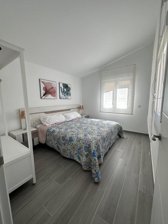 Habitación blanca con cama y espejo en DUPLEX La OLMA en Guadarrama