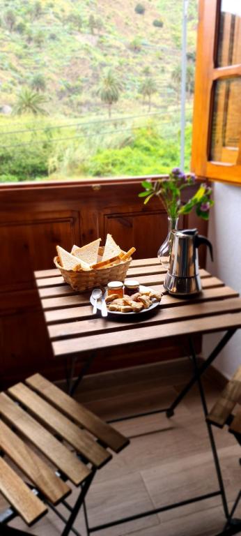 a table with a plate of food on a window at Casa Rural Antigua Escuela II in Hermigua