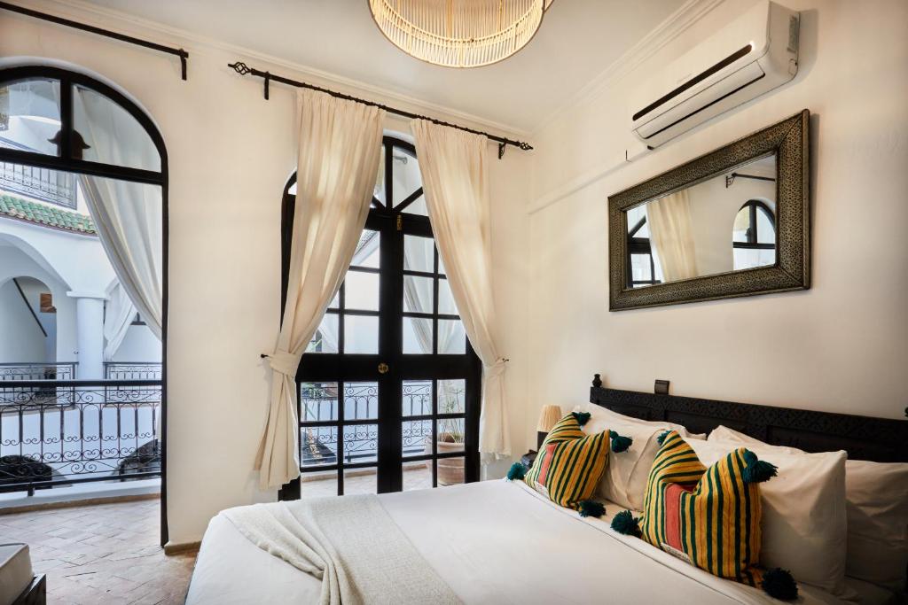 ein Schlafzimmer mit einem Bett und einem großen Fenster in der Unterkunft Riad Eldar in Marrakesch
