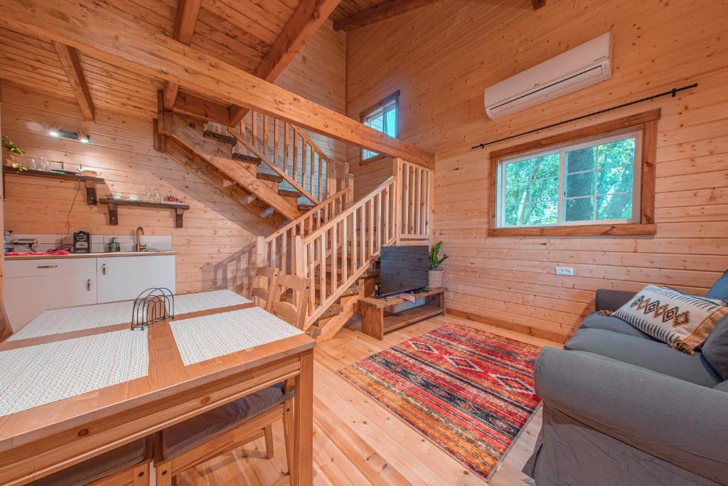 um chalé de madeira com uma escada e uma sala de estar em Zini House em Ein Zivan