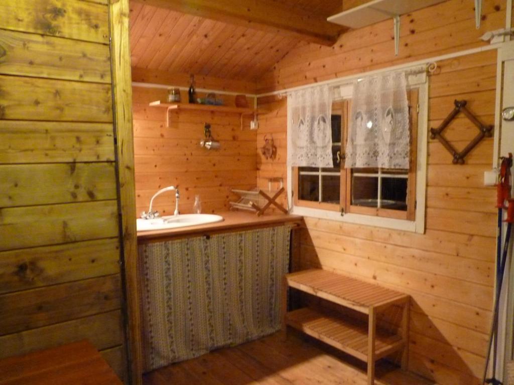 a bathroom in a log cabin with a sink and a window at Chalet en bois en pleine Nature 4 personnes 3 lits Aventure Bien être et NAture Ferme Peyrot 64 in Vielleségure