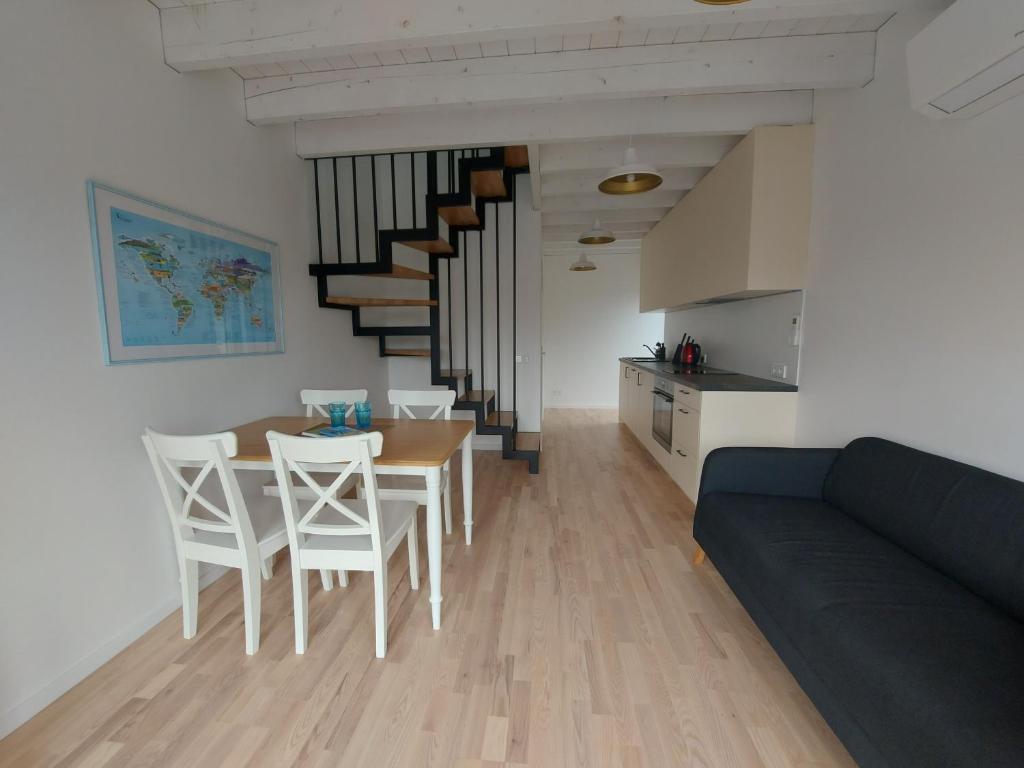 sala de estar con sofá, mesa y sillas en Kotedžas Svencelės saloje, en Svencelė