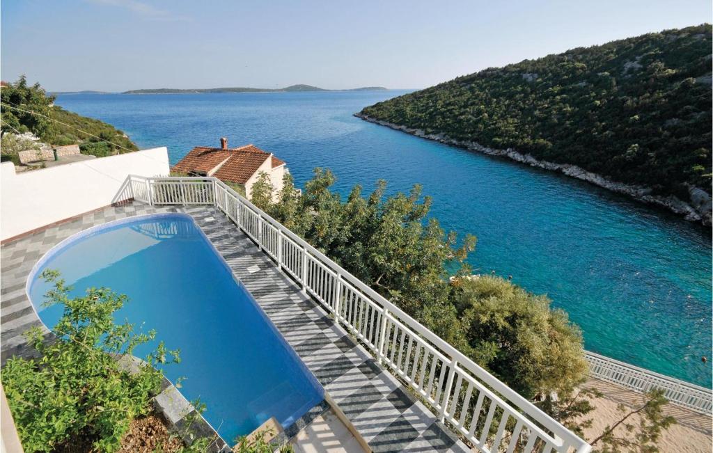 a bridge over a river with a blue pool at Gorgeous Home In Vinisce With Jacuzzi in Vinišće