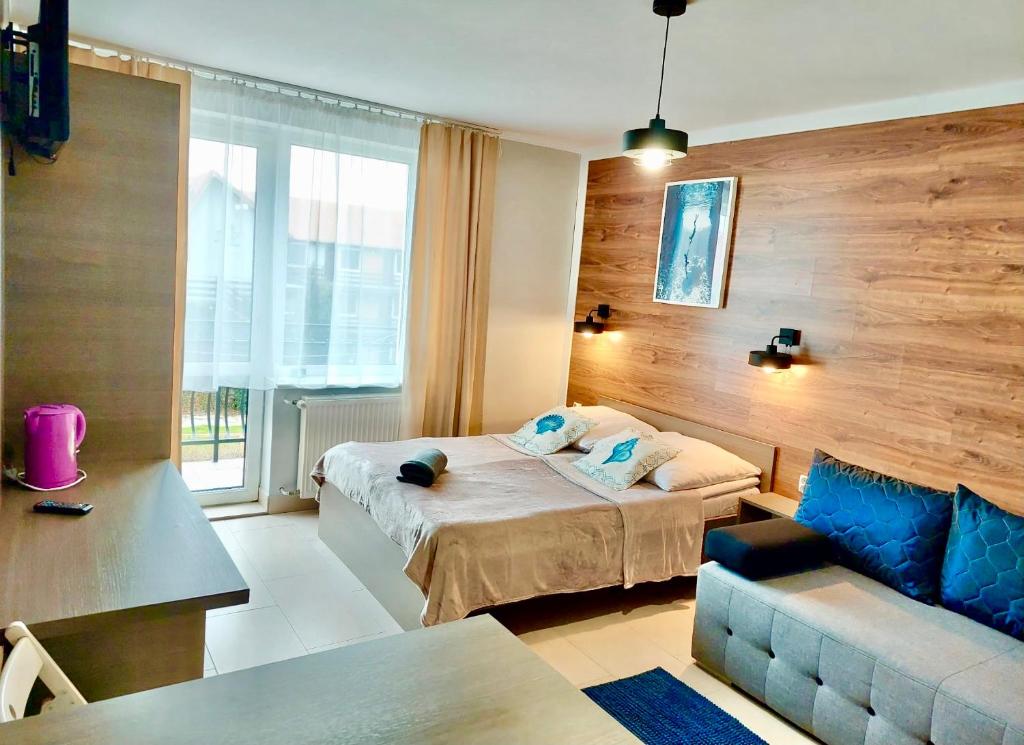 una camera d'albergo con letto e divano di Dworek Karwia Wiosenna 8 a Karwia
