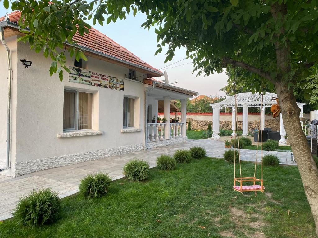 a house with a yard with a swing at Elena in Krushuna