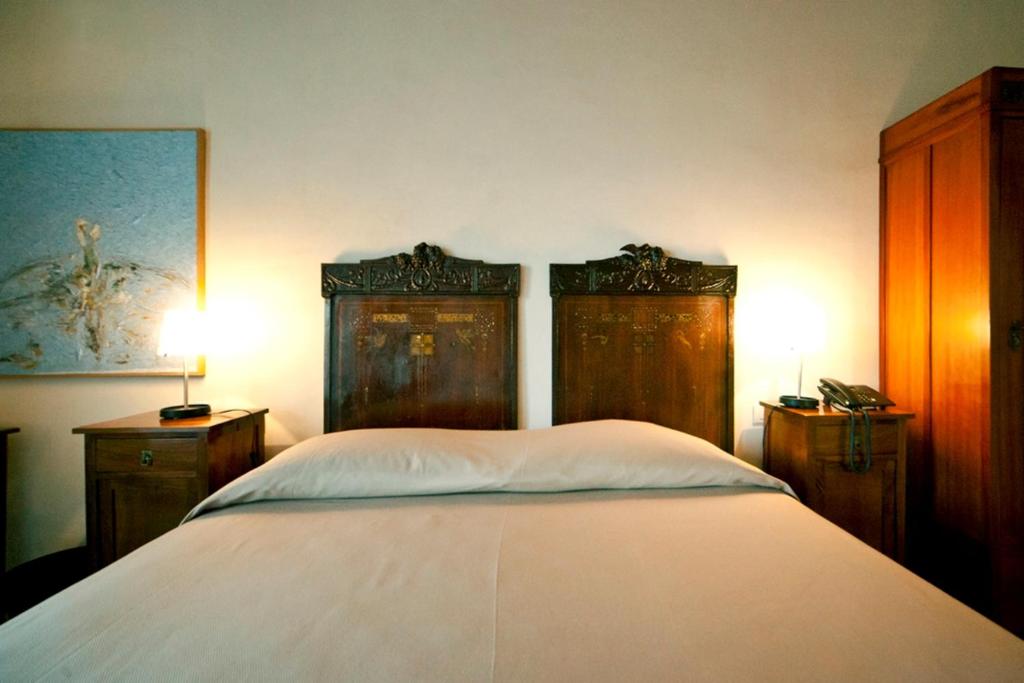 Postel nebo postele na pokoji v ubytování Hotel Dell'Orologio
