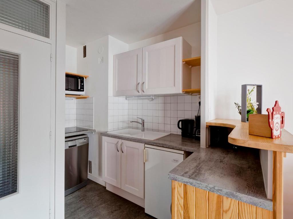 une cuisine avec des armoires blanches et un évier dans l'établissement Studio cosy pour 2 au centre de Brides-les-Bains, proche thermes et télécabine - FR-1-512-107, à Brides-les-Bains