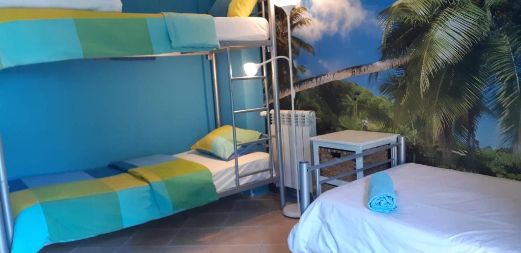 a bedroom with two bunk beds and a palm tree at Amazigh Guincho Hostel & Suítes in Cascais