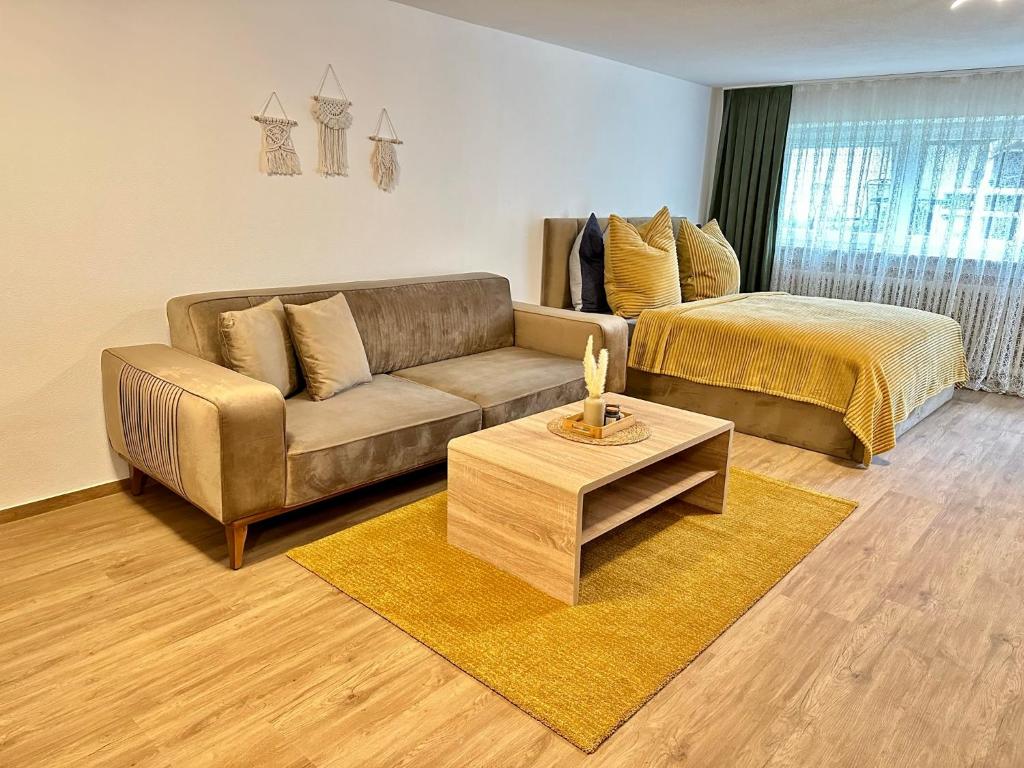 a living room with a couch and a bed at FeWo am Riedlewald in Friedrichshafen