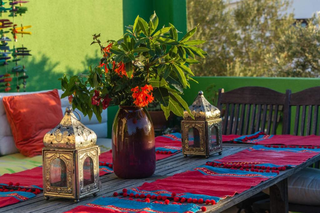 a wooden table with a vase with flowers on it at Amazigh Guincho Hostel & Suítes in Cascais