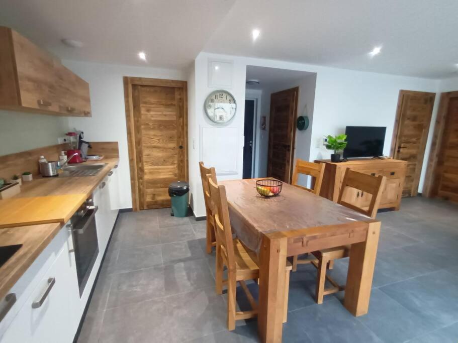 - une cuisine avec une table et des chaises en bois dans l'établissement Les rives de la jamagne, à Gérardmer