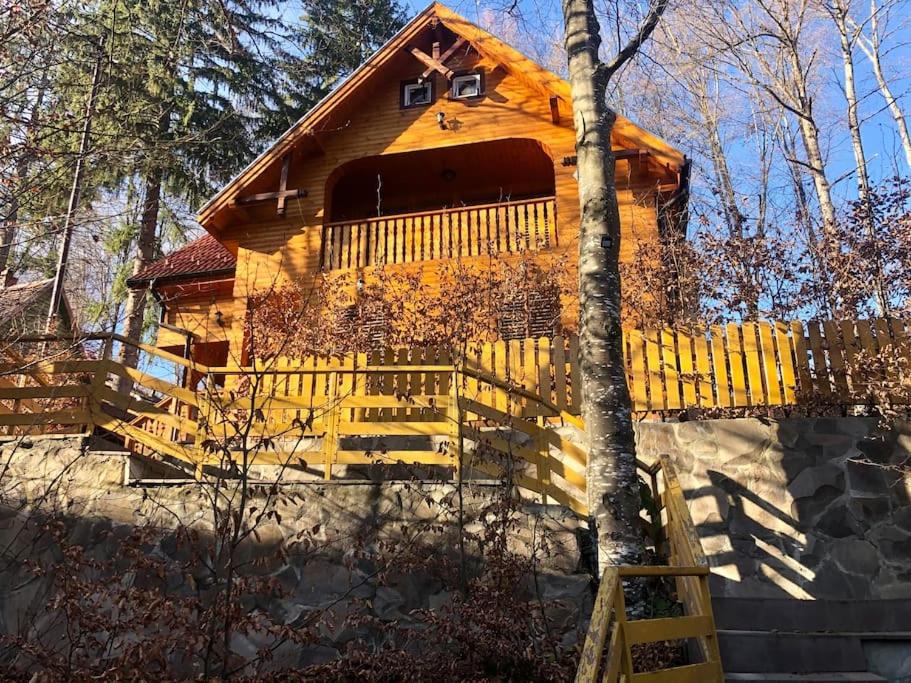 ein Blockhaus mit einem Holzzaun davor in der Unterkunft Sugas Villa in Sfântu Gheorghe