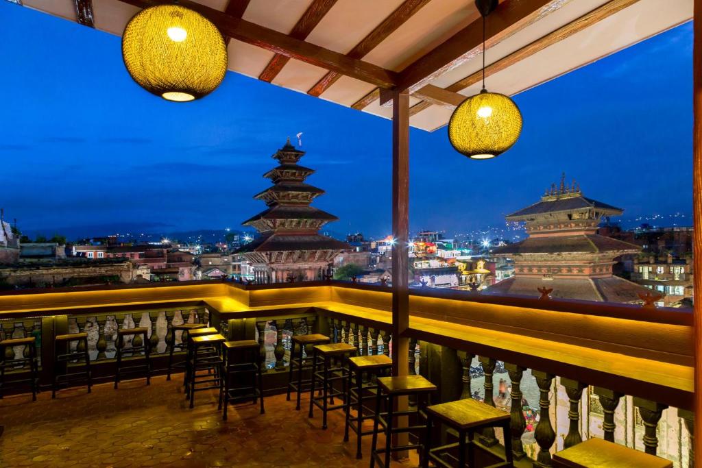 a bar with chairs and tables and a view of a city at Hotel Garuda in Bhaktapur