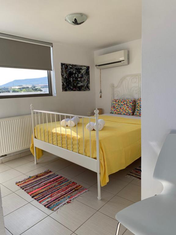 a bedroom with a yellow bed and a window at Melina Knossos Iraklio Crete in Áno Fortétsa