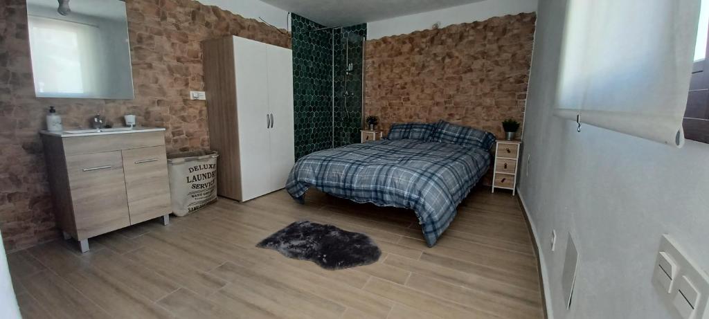 1 dormitorio con 1 cama y lavamanos. en Castra Vinaria, en Casarabonela