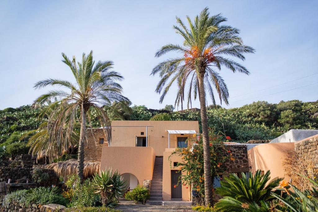 a house with palm trees in front of it at Dammuso Oltremare - Appartamento Lantana in Pantelleria