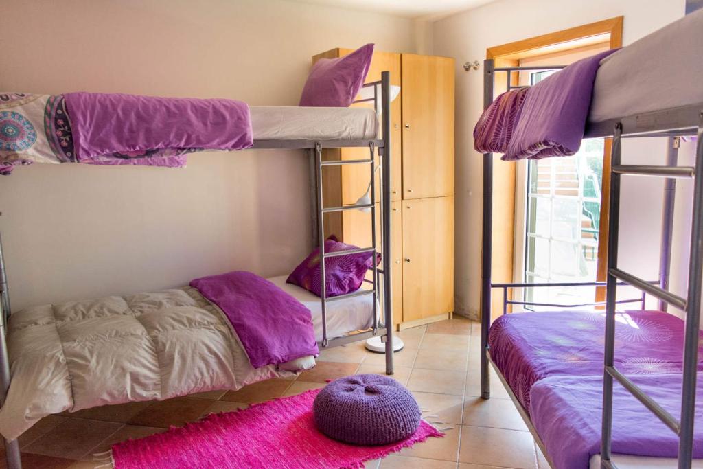 a bedroom with two bunk beds and a purple rug at Amazigh Guincho Hostel & Suítes in Cascais