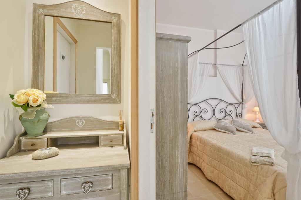 Dormitorio con cama con espejo y tocador en Maison Romantique, en Santa Maria di Castellabate