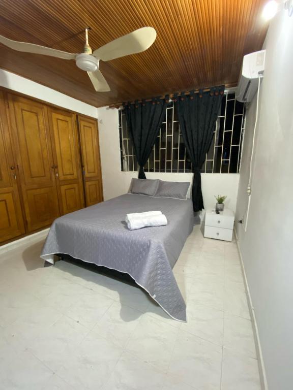 um quarto com uma cama e uma ventoinha de tecto em Habitaciones cerca al aeropuerto 2 em Cartagena das Índias