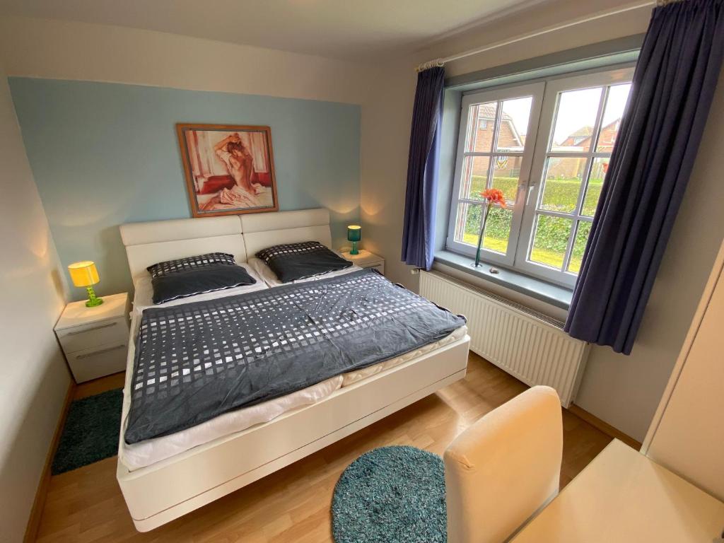 a bedroom with a bed and a window at Haus Blaubär in Friedrichskoog