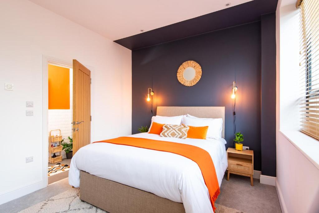 a bedroom with a large bed with an orange blanket at 15 Kingsway House in Worthing