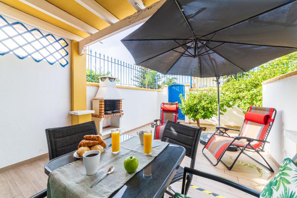 - une table et des chaises avec un parasol sur la terrasse dans l'établissement Minarete, à Roquetas de Mar