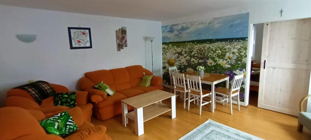 Apartament STOKROTKA في أوستكا: غرفة معيشة مع أريكة برتقالية وطاولة