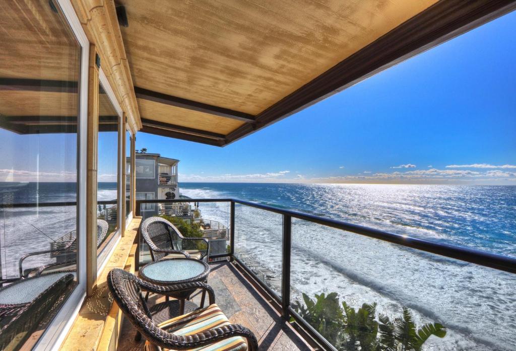 Un balcón con sillas y vistas al océano. en Villa Roma at the Retreat in Laguna Beach en Laguna Beach
