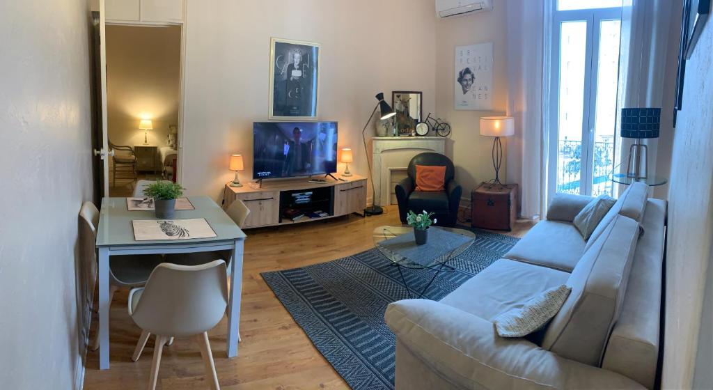 un salon avec un canapé, une table et une télévision dans l'établissement 2 pièces cannes centre, à Cannes