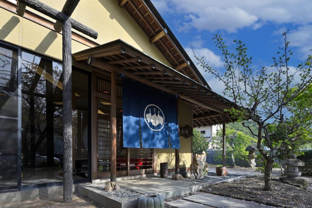 ein Gebäude mit einer Flagge auf der Seite in der Unterkunft 島の風景に溶け込む、日本の伝統旅館「かんなから」 in Tonosho